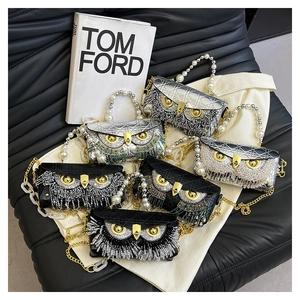 Detail of owl clutch bags with sparkling rhinestone tassels and elegant pearl handles