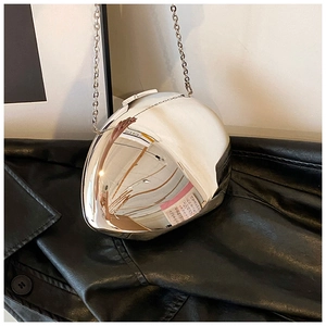 Macro shot of a silver oval acrylic box bag with a metal chain on a black leather jacket