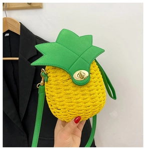 Detail of handmade pineapple straw bag with woven texture and green leaf leather flap cover