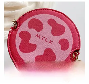 Detailed macro view of the cross-grain texture and fine stitching on the cow print bucket bag