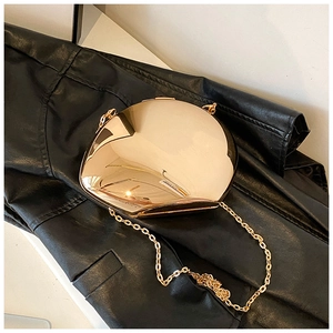 Detail of a luxury gold mirror acrylic clutch bag with a metal chain on leather