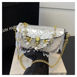 Detail of silver crossbody bag featuring rhinestone owl decor and pearl tassels