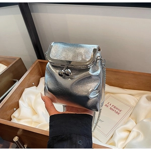 Detailed view of silver metallic pleated mini purse with vintage clasp and thin chain strap