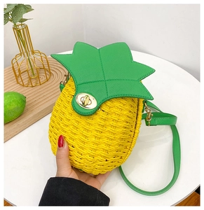 Detail of pineapple woven crossbody bag with green leaf flap and gold metal twist lock