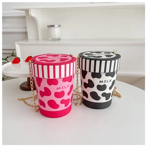 Detail of creative milk cup shaped crossbody bags with cow print and golden chain straps