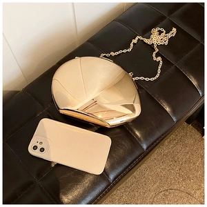 Size comparison of a gold mirror acrylic evening clutch next to a smartphone