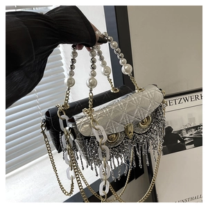 Detail of owl hardware clasp and sparkling rhinestone fringe on quilted handbag