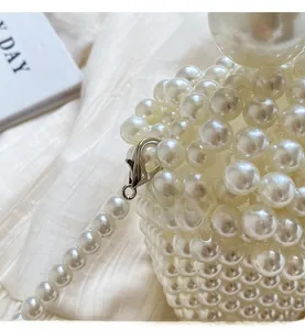 Détail du sac à main tissé de perles avec crochet métallique argenté et chaîne perlée
