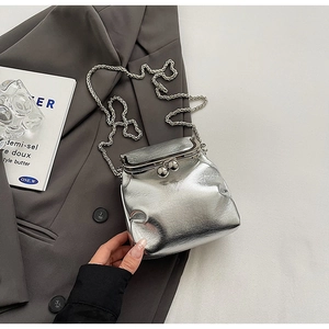 Detailed view of silver metallic pleated crossbody bag with chain strap and clasp closure