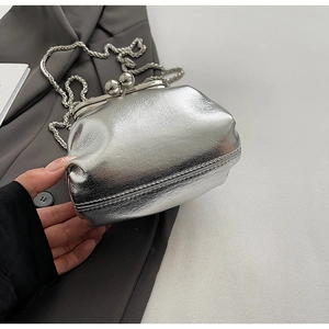Detail of silver metallic textured crossbody bag with kiss-lock and woven chain strap
