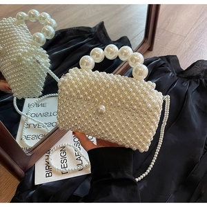 Détail du sac de plage tissé en perles montrant le grand fermoir perle et la texture satinée
