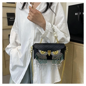 Detail of owl-shaped quilted bag with rhinestone eyes and beaded tassel fringe