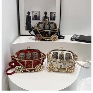 Detail of creative carriage-shaped crossbody bags in black, red, and white with gold chains