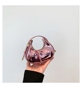 Detail of metallic pink mini half-moon bag featuring glossy finish and gold rivet accents