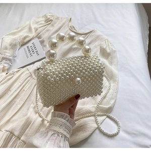 Détail du sac à main en perles blanches avec poignée perlée et bandoulière amovible