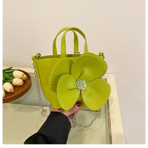 Detail of creative green petal bucket bag with 3D flower and silver chain strap