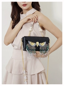 Detail showing the owl-themed handbag with colorful beaded tassels and luxury pearl handle