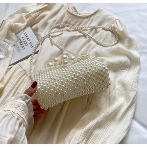 Gros plan détaillé d'un sac de soirée fait main en perles blanc crème avec fermoir perle