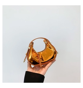 Mini metallic orange dumpling bag with glossy mirror finish and rivet detail