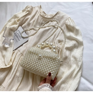 Détail du sac à main en perles blanc crème avec grand fermoir et bandoulière