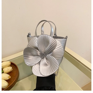 Detail of silver metallic PU bucket bag featuring a large 3D floral design and chain strap