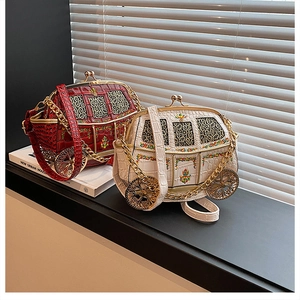 Detail of vintage carriage-shaped handbags with gold chains and crocodile texture