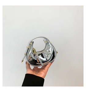 Detail shot of mini silver mirror handbag with metallic finish and crescent shape