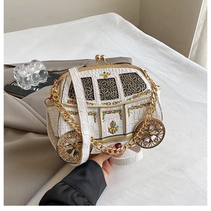 Detail of white pumpkin carriage bag with floral embroidery and golden chain strap