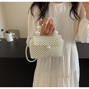 Détail du sac tissé en perles blanches avec poignée en perles et bandoulière longue