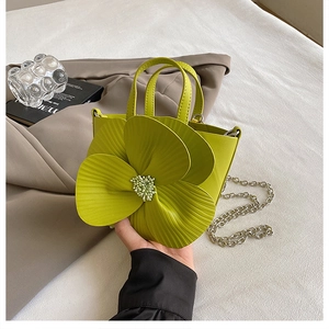 Detail of grass green petal bucket bag with 3D floral design and silver chain strap