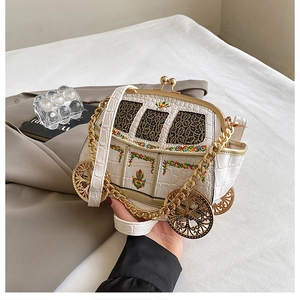 Detail of creative car-shaped crossbody bag with white crocodile texture and floral embroidery