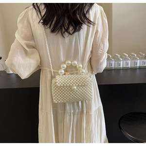 Détail du sac tissé en perles blanches fait main avec poignée en perles et chaîne bandoulière