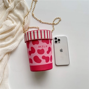 Pink milk cup shaped crossbody bag with cow print, gold chain, and 'MILK' design