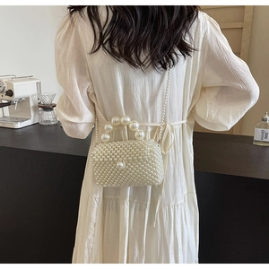 Détail du sac à main en perles blanches avec poignée en perles et fine bandoulière