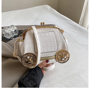 Detail of white crocodile pattern car-shaped bag with gold wheels and metal clasp