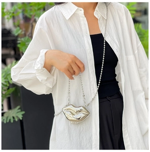 Chic silver lip-shaped acrylic mini bag with metal bead chain on a stylish model