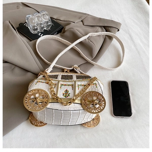 Detail of white pumpkin carriage bag with crocodile texture and gold chain strap