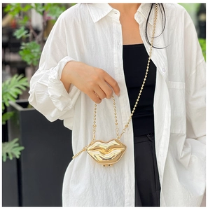 Close-up of golden lip-shaped acrylic mini bag with a beaded chain strap for women