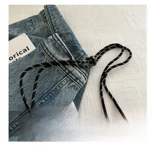 Close-up of adjustable black and white woven shoulder strap with durable hooks
