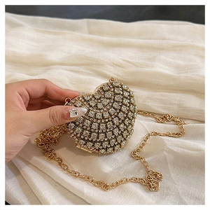 Détail d'une pochette de soirée en forme de cœur ornée de strass blancs étincelants