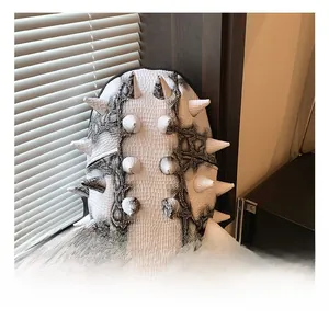 Detail shot of white spiked rivets and black faux snakeskin leather on backpack