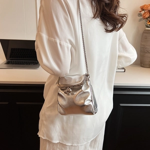 Silver pleated metallic chain bag with vintage clasp closure worn by a model