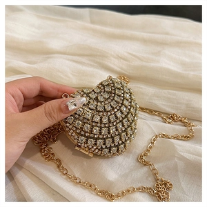 Gros plan d'une pochette de soirée en forme de cœur avec strass et chaîne dorée