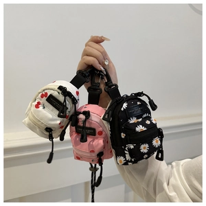 Detail of mini backpack charms with floral prints and plastic hooks for bags