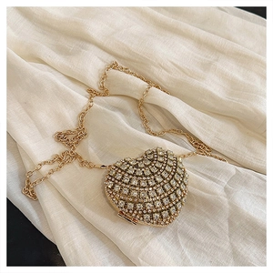 Détail du sac de soirée en forme de cœur avec strass brillants et chaîne dorée