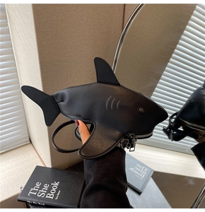 Detail of creative shark-shaped crossbody bag featuring matte leather and metal zip