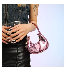Close-up of metallic pink hobo bag with glossy finish held by model in Y2K style