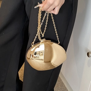 Polished gold pebble acrylic clutch bag with fine chain strap for evening wear
