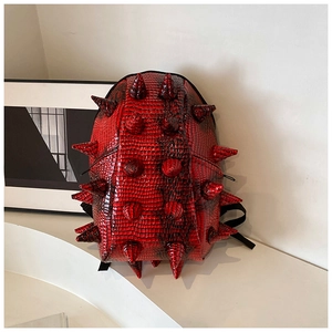 Detail of red punk hedgehog backpack with spike studs and crocodile leather texture