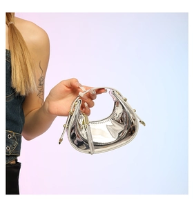 Close-up of silver mirror moon bag with metallic studs and slender handle detail